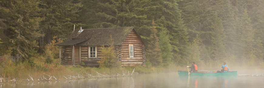 Un couple dirige son canot vers la cabane de Grey Owl dans le brouillard.