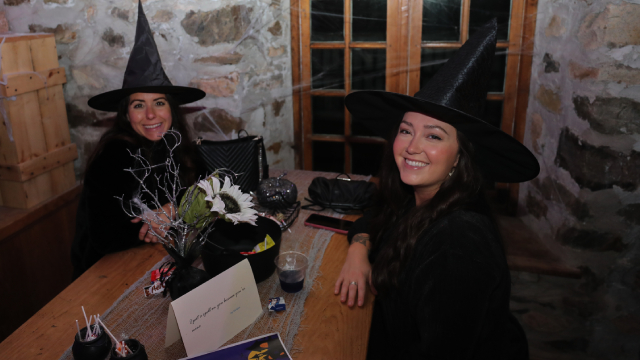 Deux femmes vêtues de costumes de sorcières sourient à la caméra.