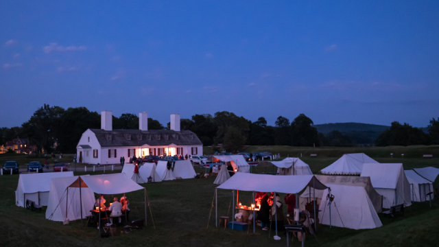 Une réplique d'un campement militaire du 18e siècle sur la pelouse en soirée. 
