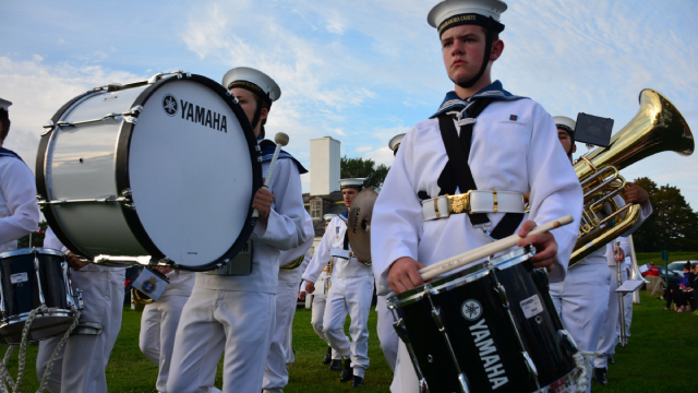 A marching band in white uniforms.