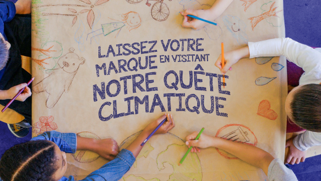 Des enfants dessinent sur l’affiche de l’exposition « Notre quête climatique ».