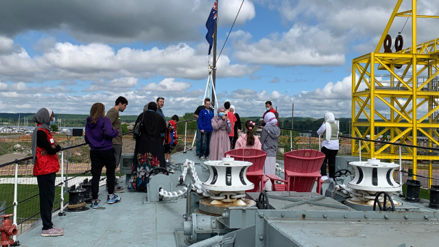 Un groupe de visiteurs et des bénévoles sur le pont du destroyer de classe Tribal.