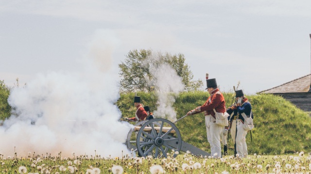 Des guides en uniforme de soldat se préparent à tirer au canon.