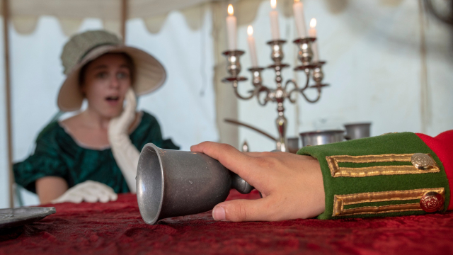 Une jeune femme en costume d’époque a une expression surprise.
