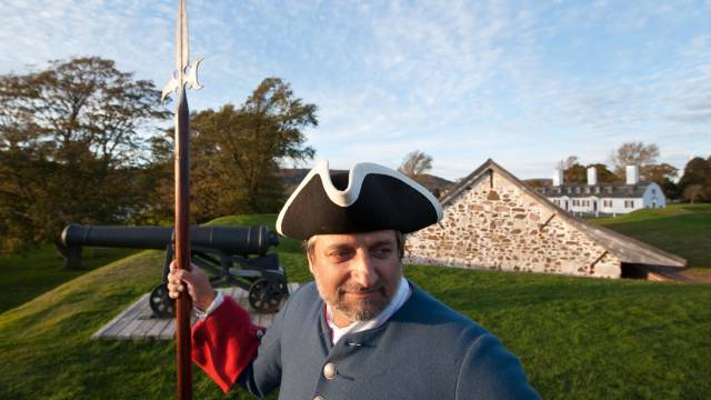 Un homme déguisé en guide historique pose pour une photo.