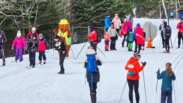 A group of instructors and children cross-country skiing with Parka at La Mauricie National Park.