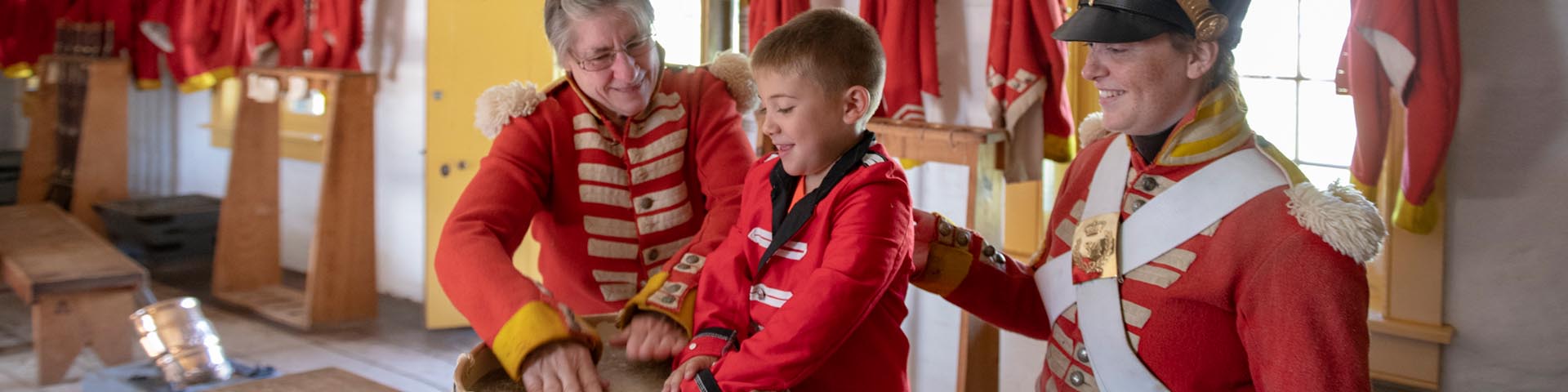 Costumed visitors drum with a soldier at Fort Malden National Historic Site.