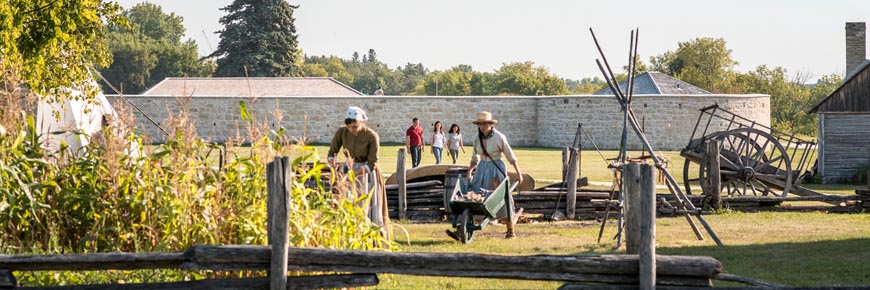 Guides in historic costumes work in the garden at the Farm Manager's Cottage.