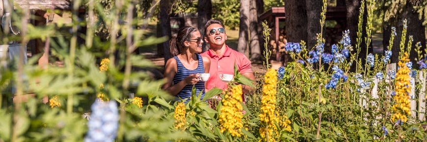 Deux visiteurs savourent une tasse de thé en explorant les jardins anglais derrière le centre d’accueil.