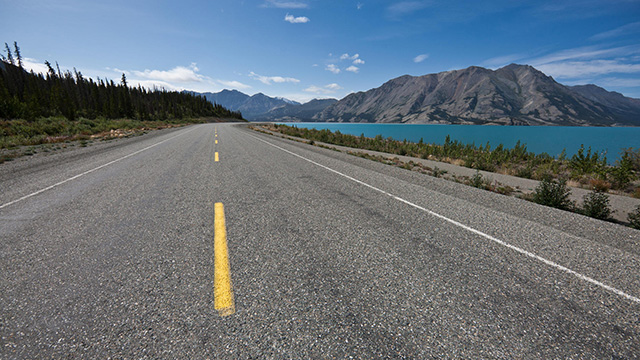 Panorama sur un lac turquoise et sur les montagnes sur la route de l’Alaska dans la vallée Ä’äy Chù.