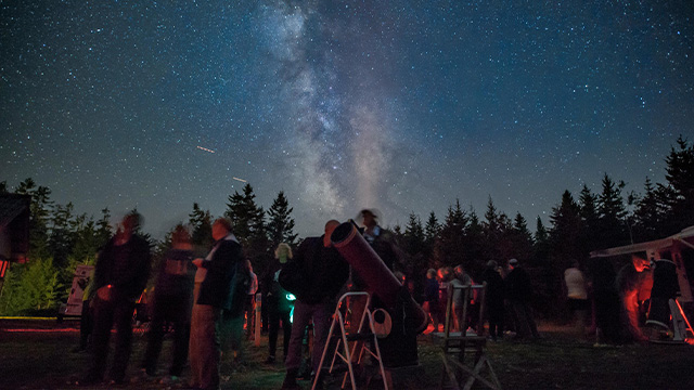 Astronomes amateurs regardant la Voie lactée lors d’un rassemblement.