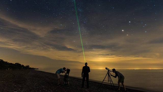 Des visiteurs observent le ciel à l’aide de télescopes à la plage West.