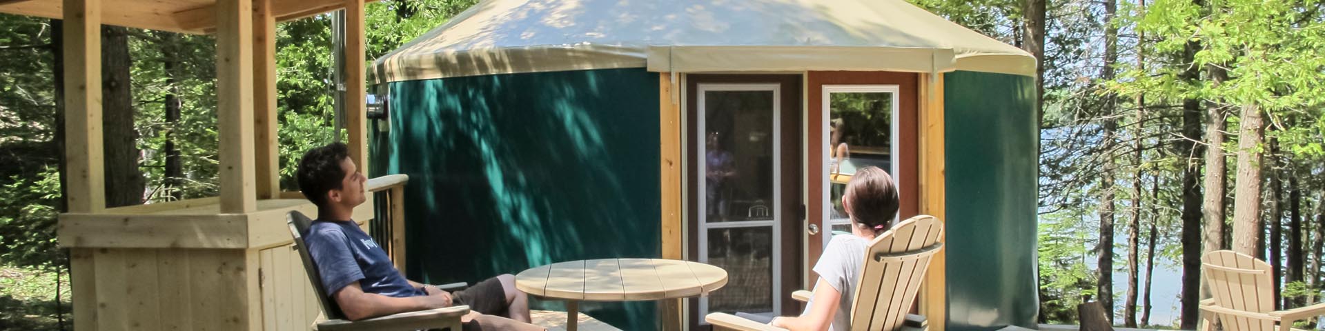 	Two visitors relax on the patio of the yurts located along the shoreline of Cyprus Lake.