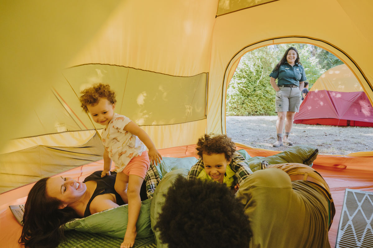 A family of four playing together in a yellow tent.