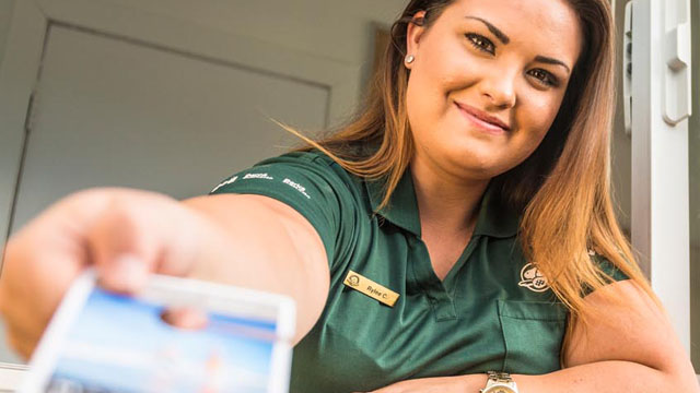 Parks Canada staff hands out visitor information at the entrance kiosk.