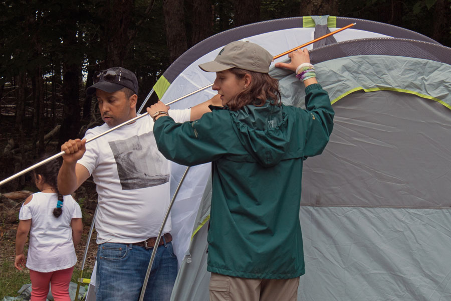 Learn-to camp staff person and participant set up a tent pole.