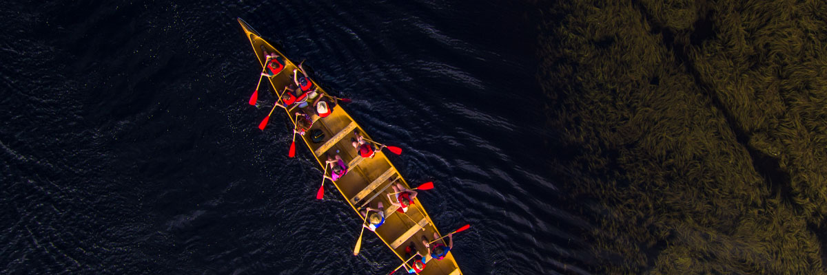 A large fibre glass canoe carrying eleven people.