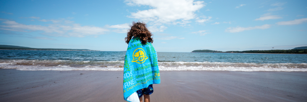 Une jeune fille avec sa serviette sur la plage de la Baie North.