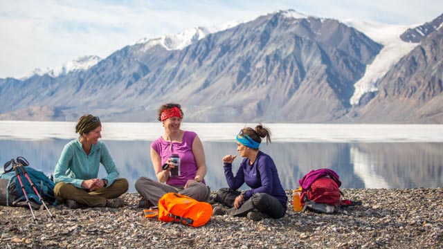 Hikers taking a break at Tanquary Fiord with Gull Glacier in the background.