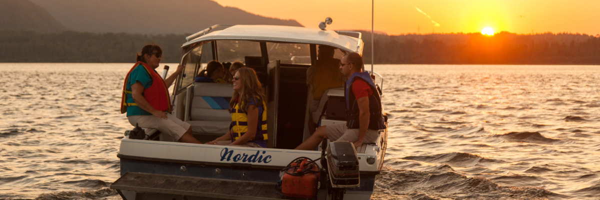 Une famille fait une promenade en bateau le soir sur le lac Supérieur.