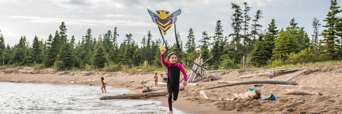 Une jeune fille fait voler un cerf-volant sur la plage Horseshoe.