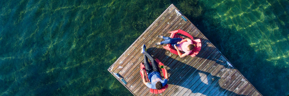 Deux visiteurs sur des chaises sur un quai du parc national des Mille-Îles