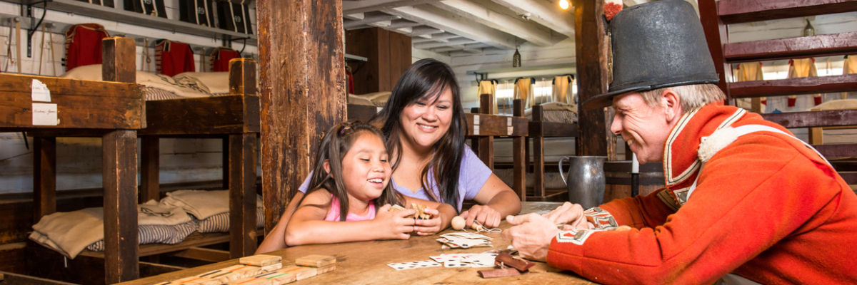 Visitors play cards in the Soldier’s Barracks at Fort George National Historic Site
