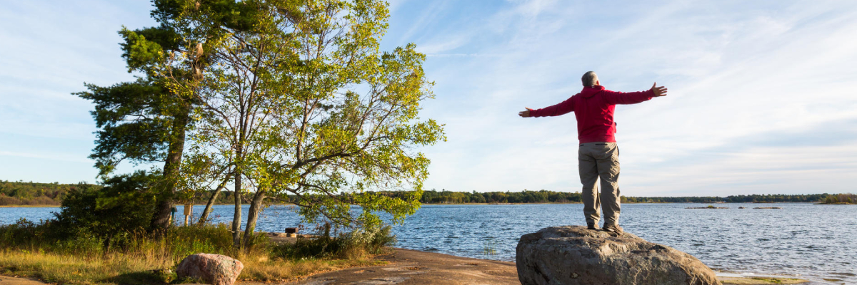 A hiker soaks up the shoreline scenery at Thumb Point on Beausoleil Island.