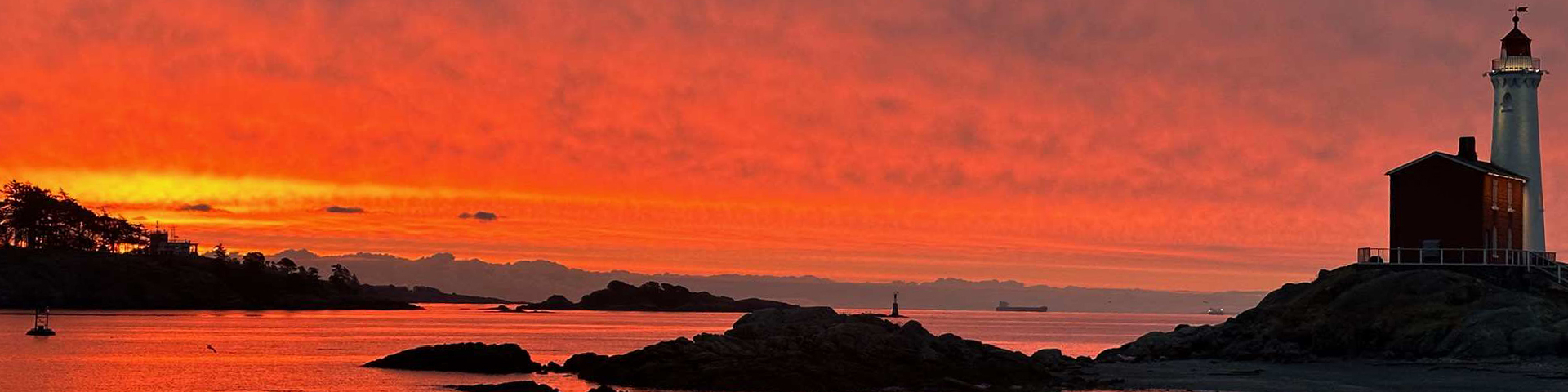 A view of the lighthouse by the sea at Fisgard Lighthouse National Historic Site.