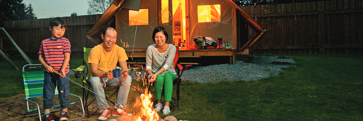 Une famille profite d’un feu de camp devant une oTENTik