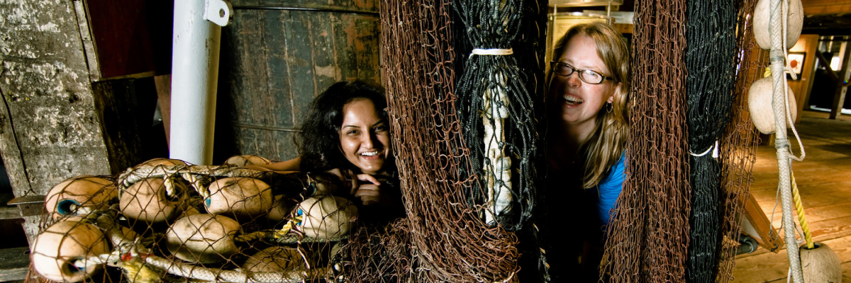 Des femmes découvrent le matériel de pêche dans une exposition