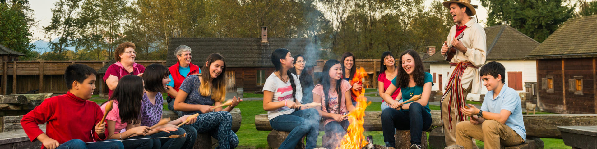 A guide in period costume leads a campfire at the Fort Langley National Historic Site.
