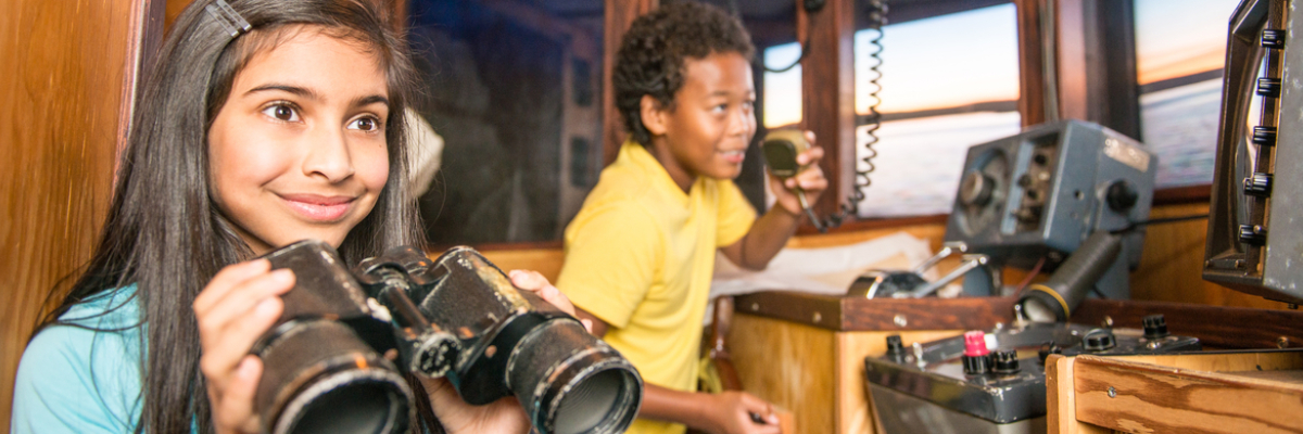 Children pretend to be skippers and fishermen in the replica bridge of a trawler