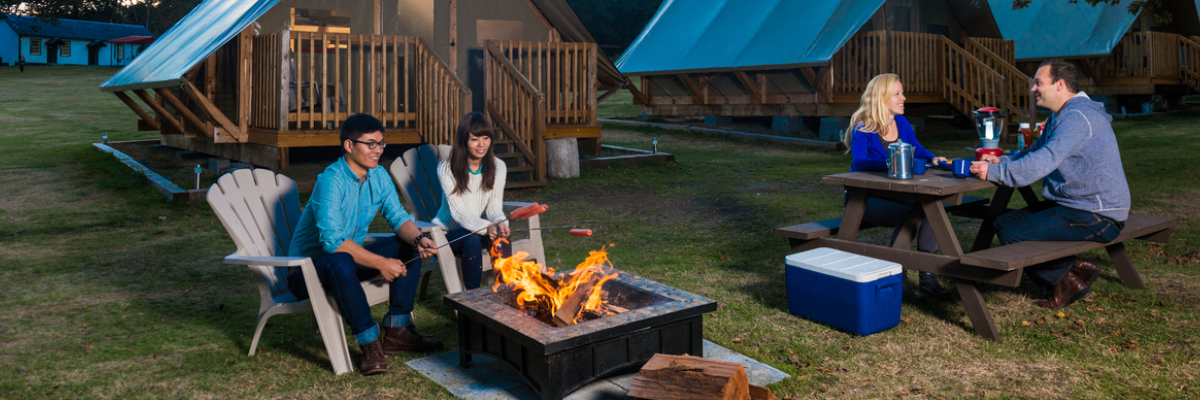 Two couples enjoy the evening in front of the oTENTik tents