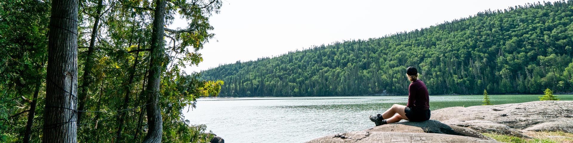 Une femme assise sur un rocher surplombant le lac