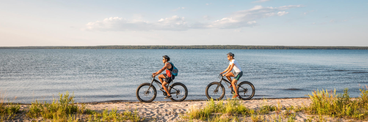 Visitors ride fat bikes along the beach on South Lake Trail. 