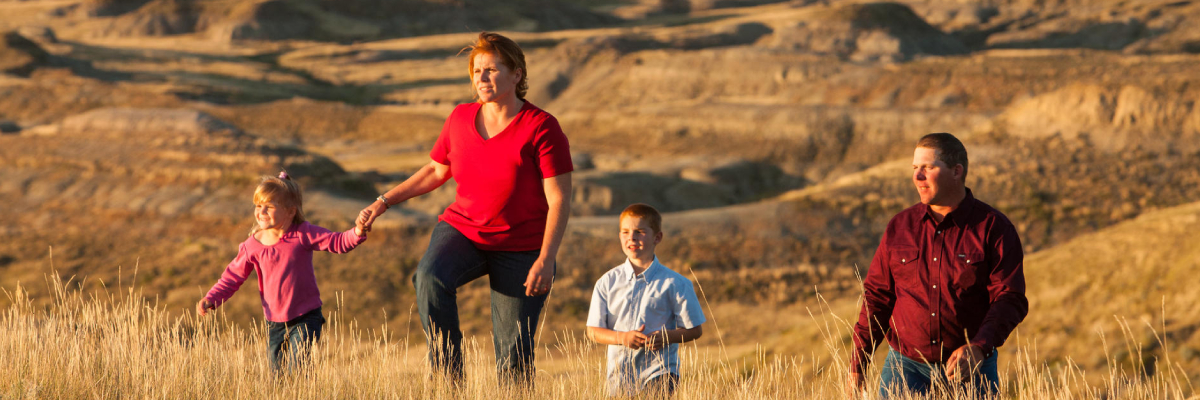 A family of four watching the sunset on the prairies.