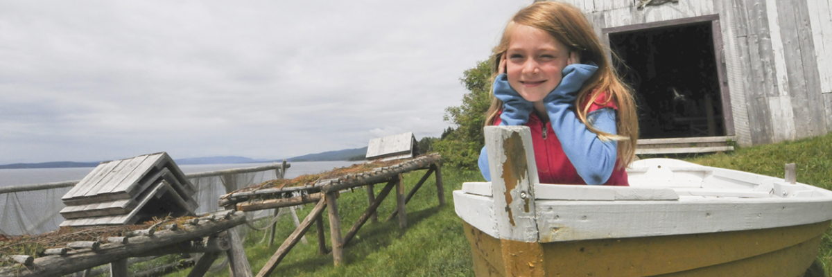 Une jeune fille dans une chaloupe au site historique de Grande-Grave.