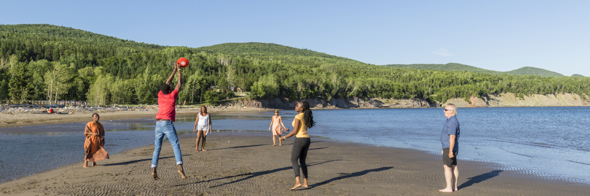 Visitors play frisbee at Penouille beach.