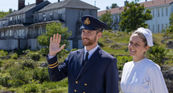 Two costumed interpreters in front of the Second-Class Hotel and the Third-Class Hotel at the entrance of the national historic site.
