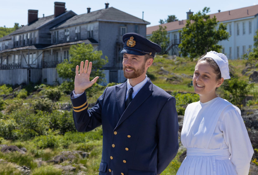 Two costumed interpreters in front of the Second-Class Hotel and the Third-Class Hotel at the entrance of the national historic site.