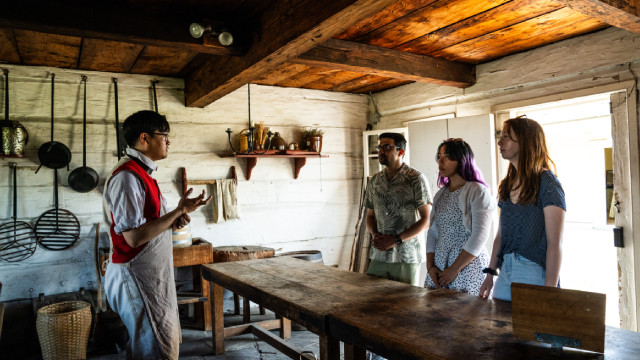 Des visiteurs avec un guide en costume d'époque au lieu historique national du FortGeorge.