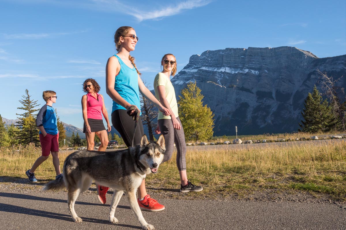 A family walks their dog at Tunnel Mountain Campground during a fall afternoon. Banff National Park.