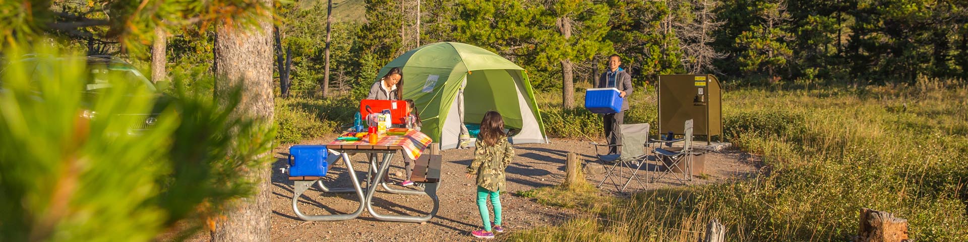 Une jeune famille campe sur l'un des emplacements équipés du camping du Mont-Crandell, au parc national des Lacs-Waterton. 