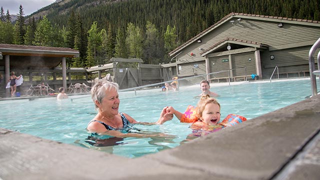 Two adults and a toddler in a pool.