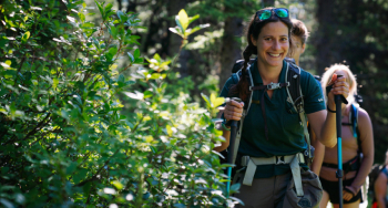 Un guide en uniforme avec un groupe lors d'une randonnée de conservation jusqu’aux lacs Consolation.