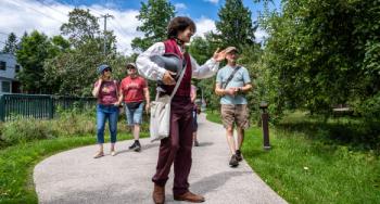 A guide in historic costume leads visitors at Bellevue House National Historic Site.